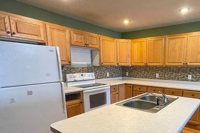 kitchen with light countertops, white appliances, a sink, and decorative backsplash