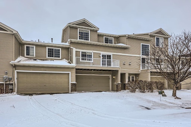 view of property with an attached garage and a balcony