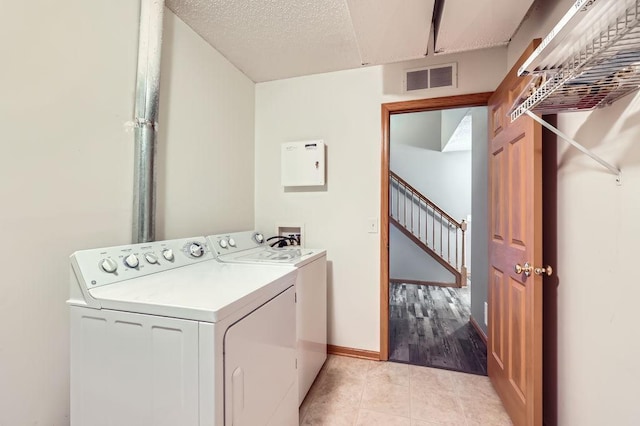 laundry room featuring visible vents, light tile patterned flooring, washer and dryer, laundry area, and baseboards