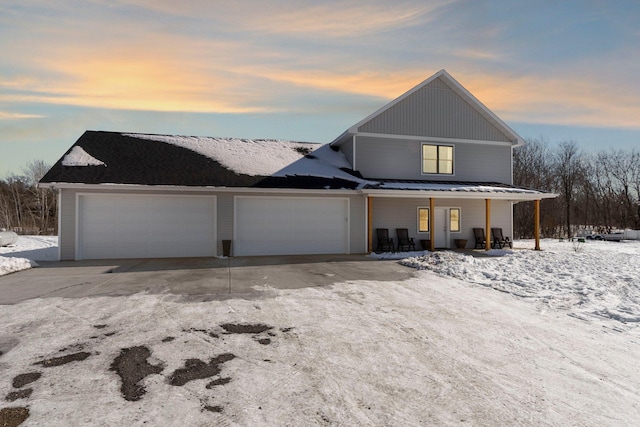 view of front of property with an attached garage, driveway, and a porch