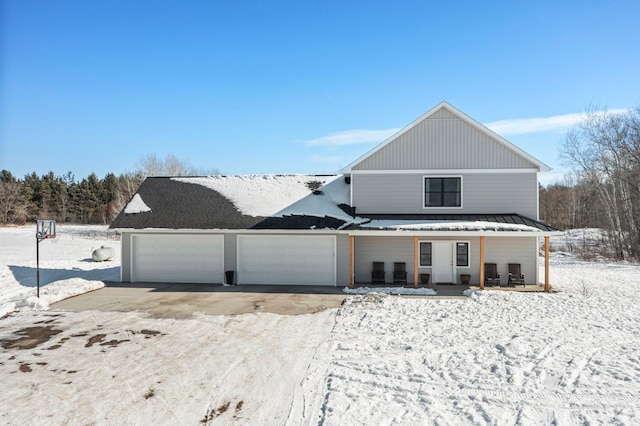 view of front of property with covered porch, metal roof, driveway, and a standing seam roof