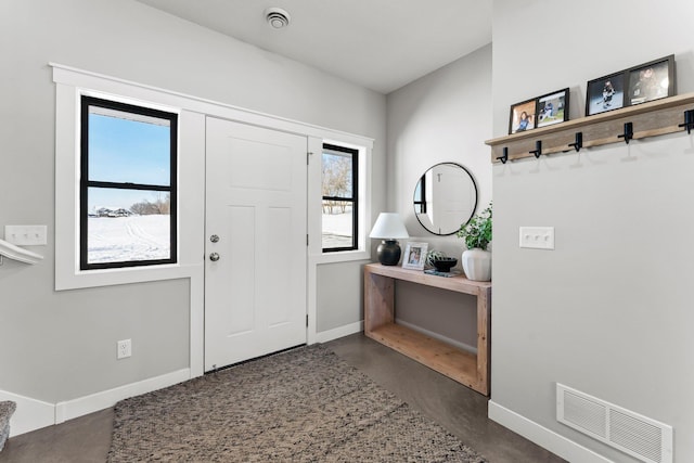 entryway with finished concrete flooring, baseboards, and visible vents