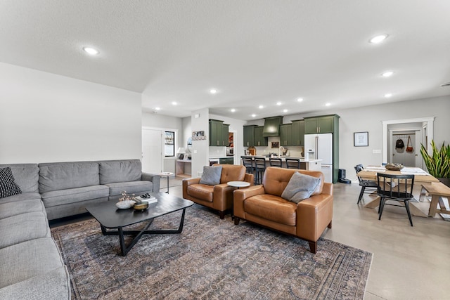 living room featuring finished concrete flooring, a textured ceiling, and recessed lighting