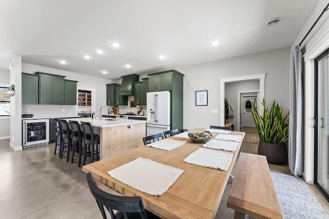 dining area with wine cooler, recessed lighting, visible vents, a healthy amount of sunlight, and concrete flooring