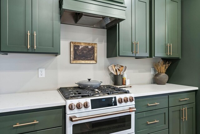 kitchen with light stone counters, premium range hood, high end white range oven, and green cabinets