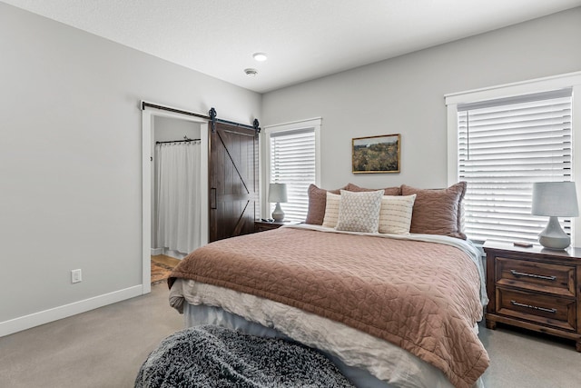 bedroom featuring a barn door and baseboards