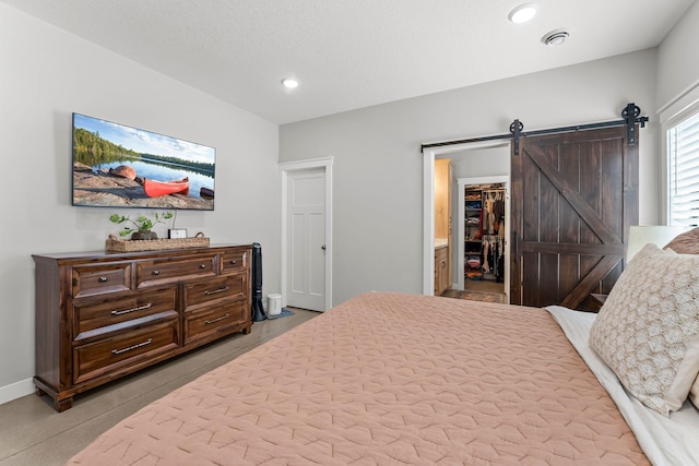 bedroom with baseboards, a spacious closet, a barn door, and recessed lighting