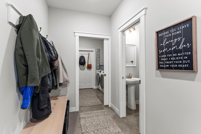 interior space with concrete flooring, washing machine and clothes dryer, and baseboards