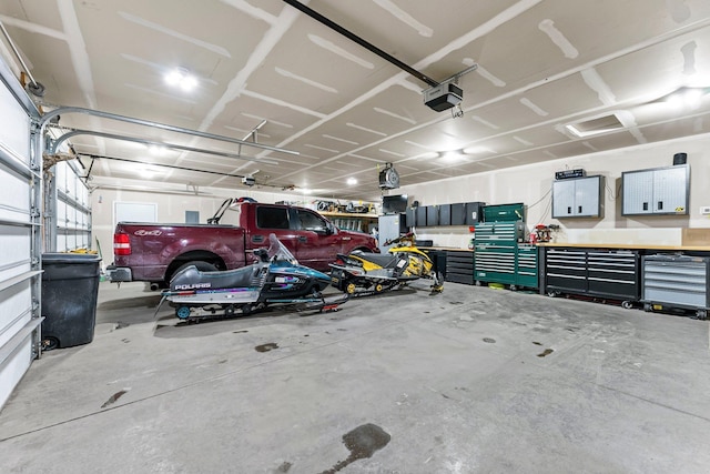 garage with a garage door opener and a workshop area