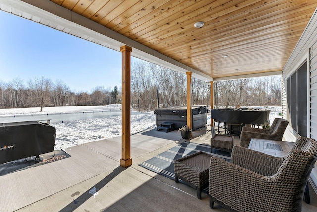 snow covered patio with a hot tub