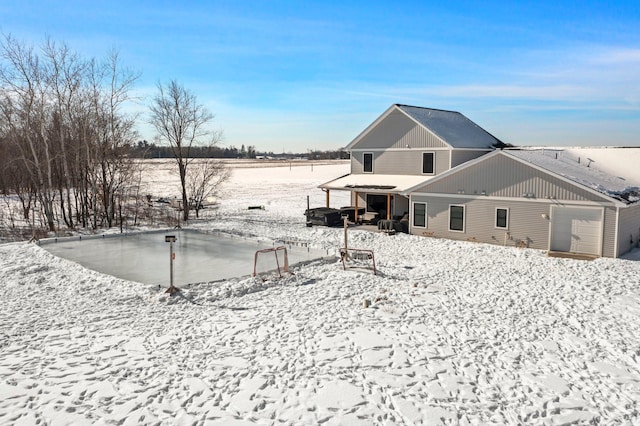 view of snow covered rear of property