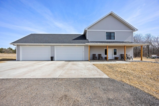 view of front facade with a standing seam roof, a porch, metal roof, concrete driveway, and a garage