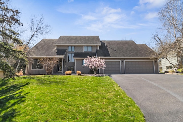 view of front of home with a shingled roof, an attached garage, driveway, and a front lawn