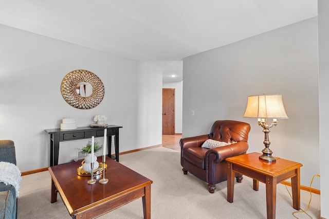 living area featuring light colored carpet and baseboards