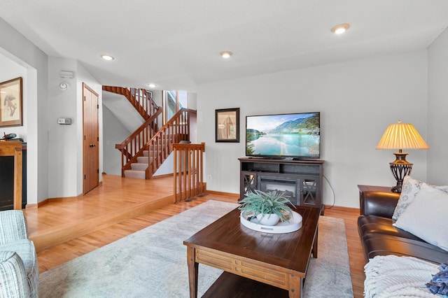 living area with stairs, recessed lighting, baseboards, and wood finished floors