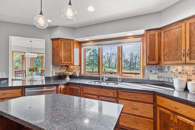 kitchen with a sink, brown cabinetry, decorative light fixtures, tasteful backsplash, and stainless steel dishwasher