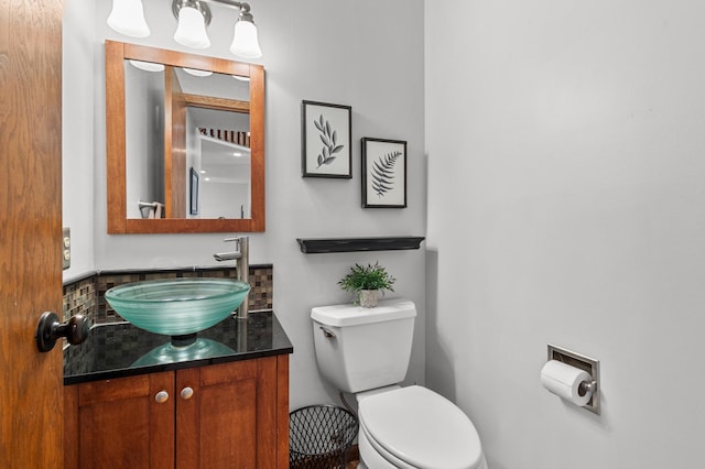 bathroom with vanity, toilet, and tasteful backsplash