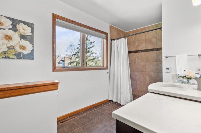 full bath featuring a sink, tile patterned floors, baseboards, visible vents, and tiled shower