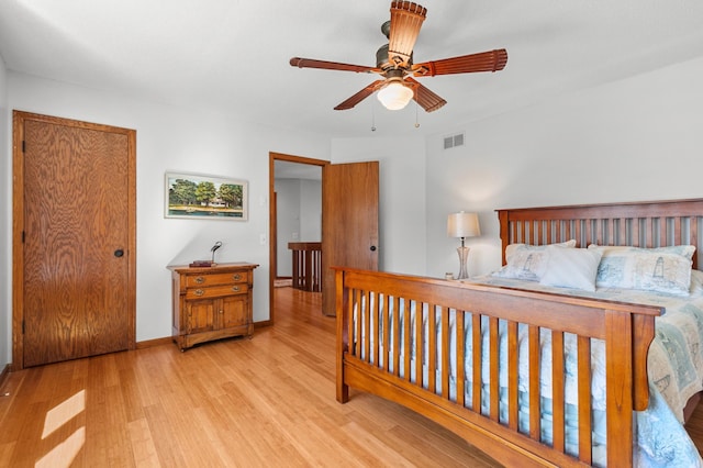bedroom with ceiling fan, baseboards, visible vents, and wood finished floors