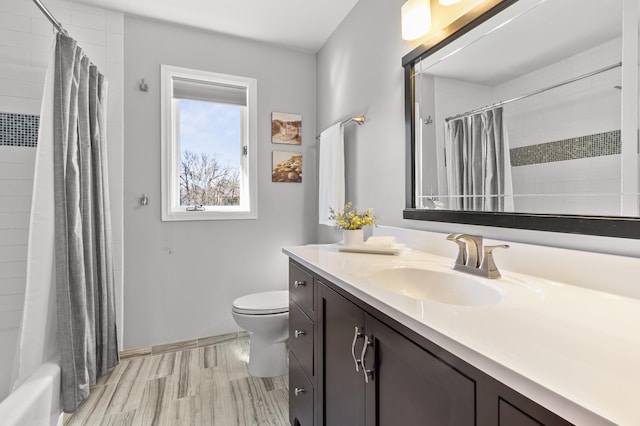bathroom featuring vanity, baseboards, and toilet