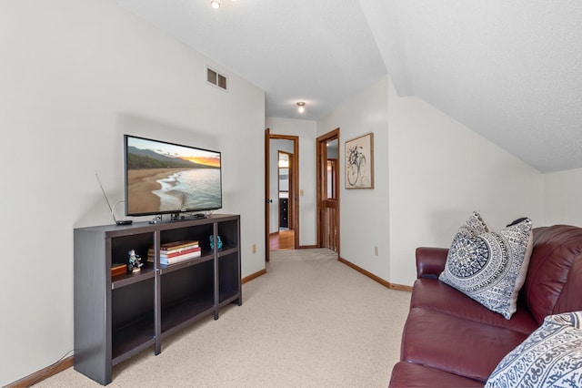 carpeted living area featuring visible vents, baseboards, and lofted ceiling