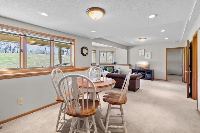dining space featuring baseboards, light carpet, recessed lighting, and a textured ceiling