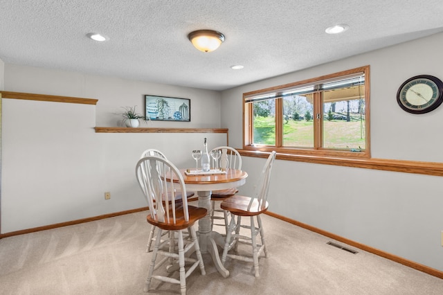 dining space with baseboards, carpet, and visible vents