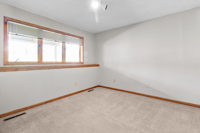 unfurnished room featuring visible vents, carpet flooring, and baseboards