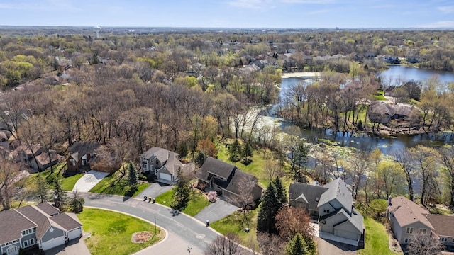bird's eye view with a water view, a view of trees, and a residential view