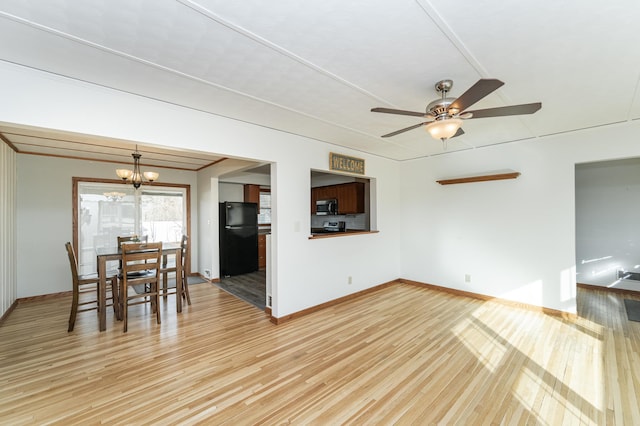 interior space with light wood-type flooring, baseboards, and ceiling fan with notable chandelier