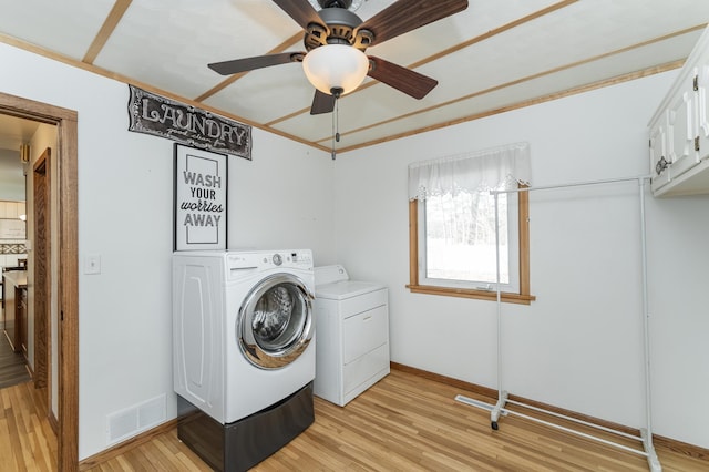 washroom featuring visible vents, cabinet space, light wood-type flooring, independent washer and dryer, and baseboards