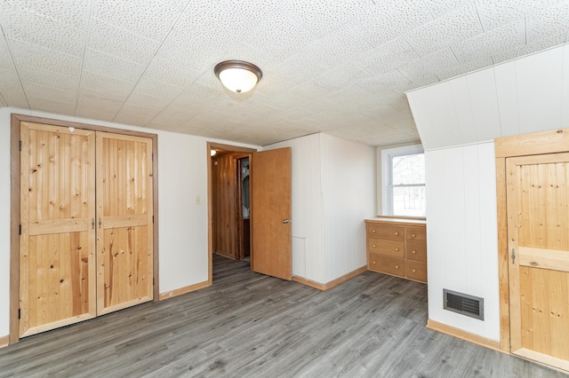 interior space featuring visible vents, baseboards, and wood finished floors