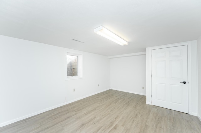 unfurnished room with light wood-style flooring and baseboards