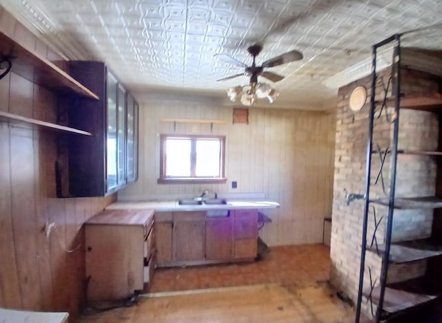 3285 Vermilion Trl, Colvin Twp, MN 55763 - kitchen featuring a ceiling fan, an ornate ceiling, a sink, light wood-style flooring, and wooden walls