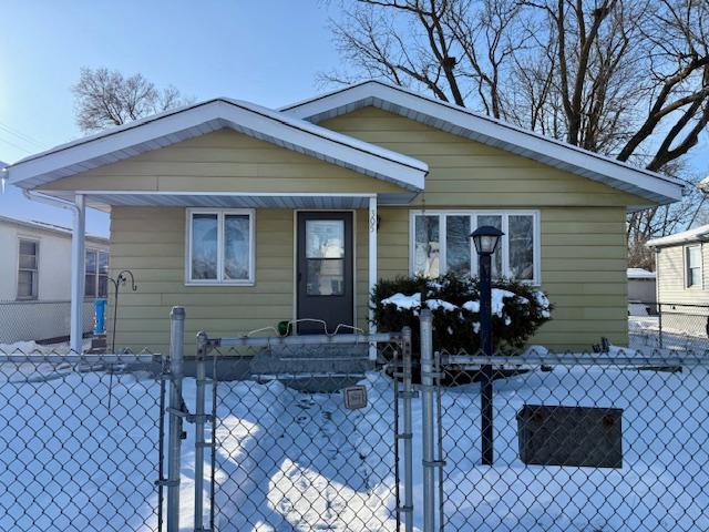 bungalow featuring a fenced front yard and a gate