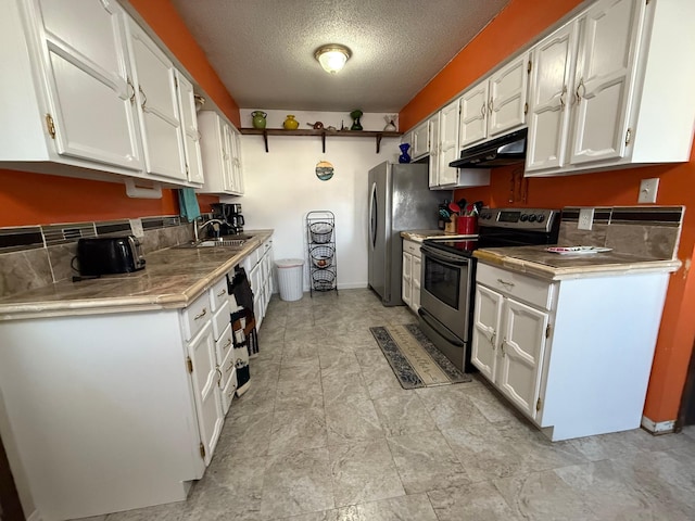 kitchen with under cabinet range hood, stainless steel appliances, and white cabinets