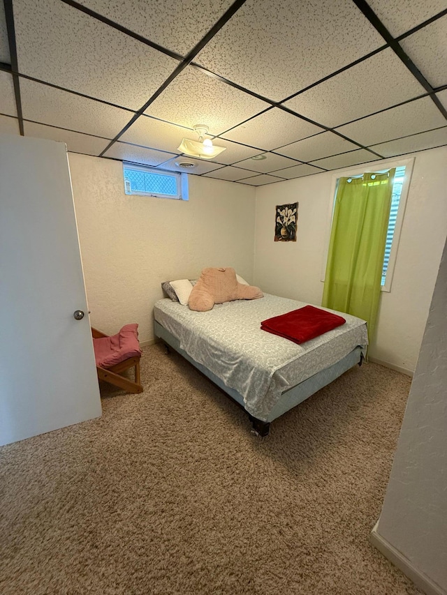 carpeted bedroom with a drop ceiling