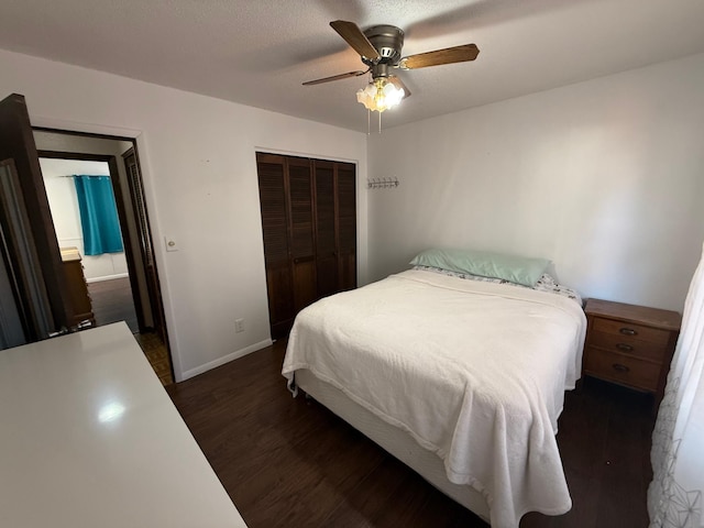 bedroom with baseboards, dark wood finished floors, ceiling fan, and a closet