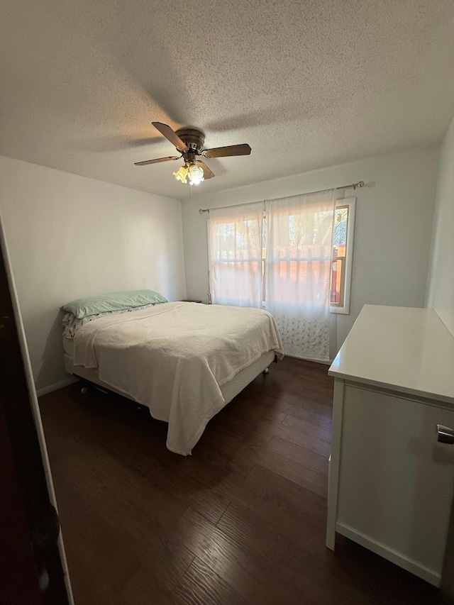 bedroom featuring a ceiling fan, dark wood-style floors, and a textured ceiling