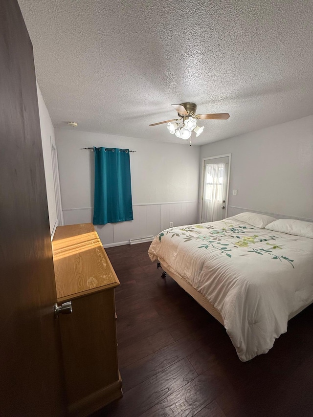 bedroom featuring a ceiling fan, a textured ceiling, and dark wood-style floors