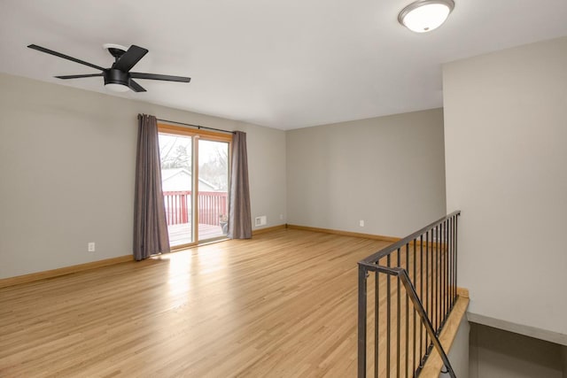 empty room with light wood-style floors, ceiling fan, and baseboards