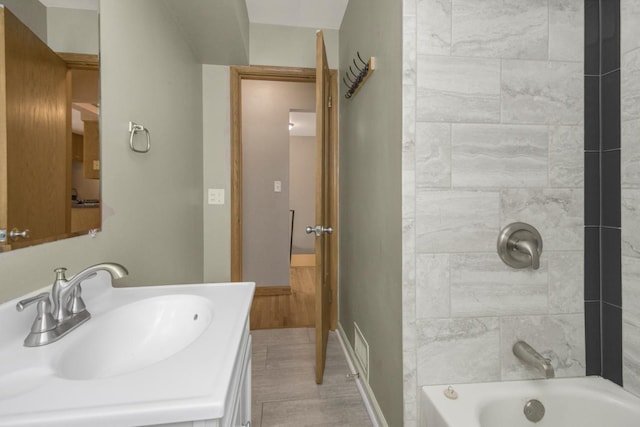 bathroom with visible vents, shower / bathing tub combination, vanity, and baseboards