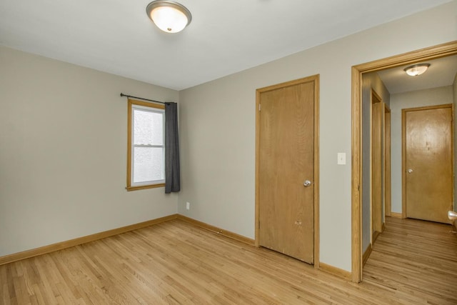 empty room with light wood-type flooring and baseboards