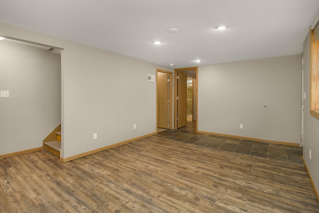 empty room with stairs, recessed lighting, wood finished floors, and baseboards