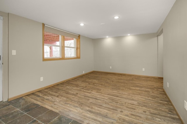 empty room with baseboards, wood finished floors, and recessed lighting