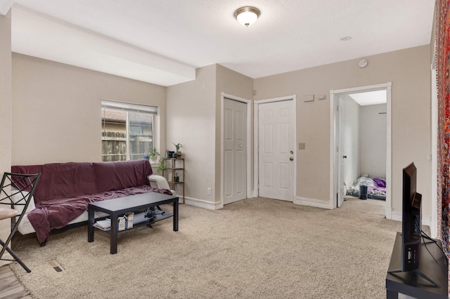 living area with light carpet and baseboards