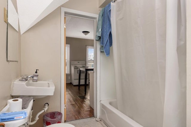 bathroom featuring wood finished floors, a sink, toilet, and shower / bath combo with shower curtain