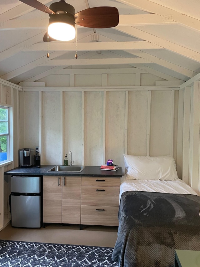 bedroom with wooden walls, vaulted ceiling, a sink, and freestanding refrigerator