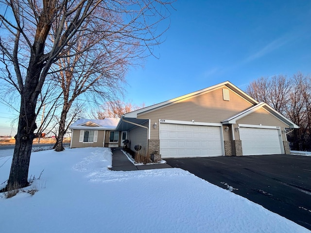 single story home featuring driveway, a garage, and brick siding