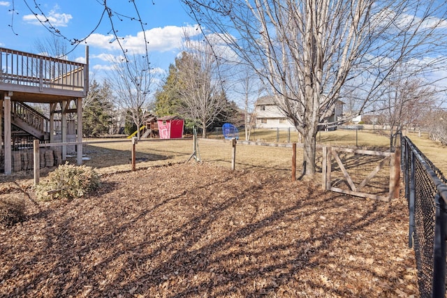 view of yard with stairs, fence, and a wooden deck